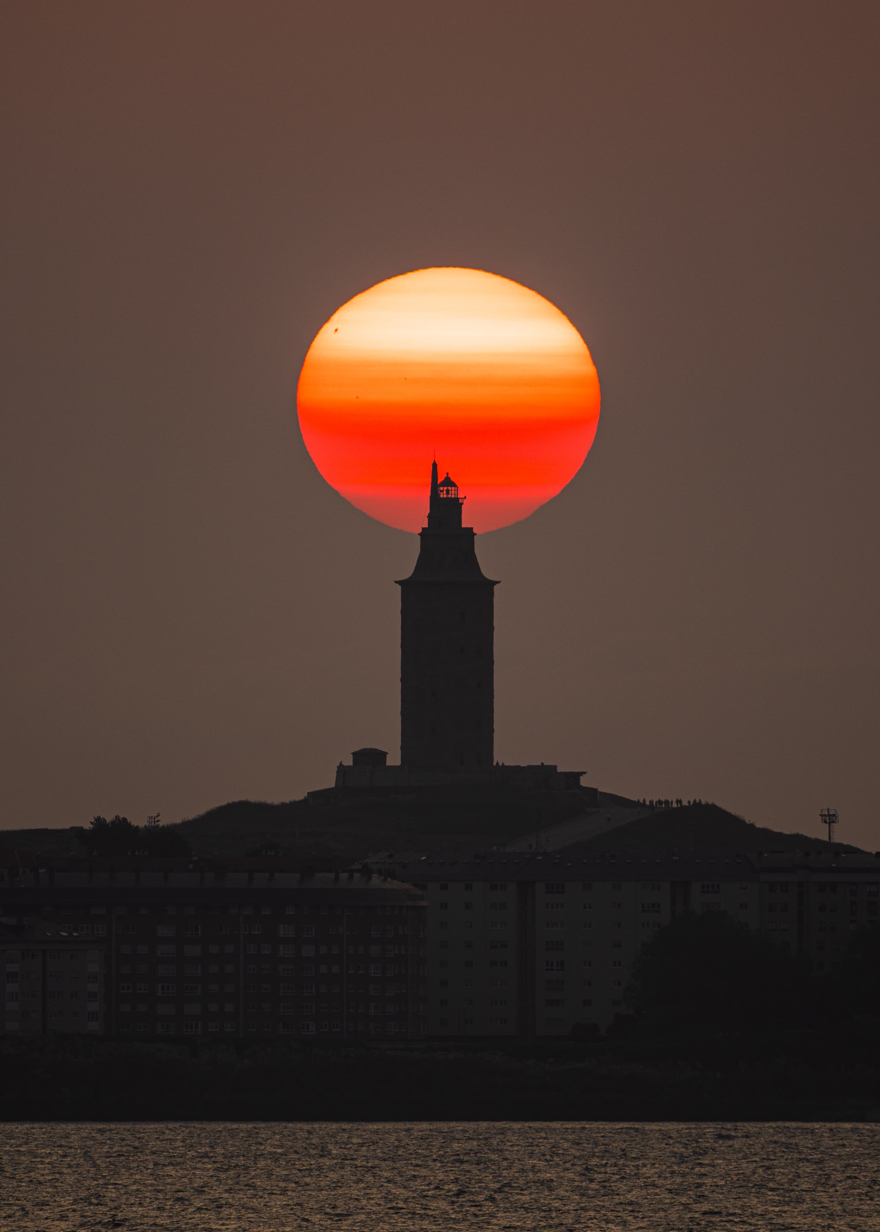 Torre de Hércules sol rojo